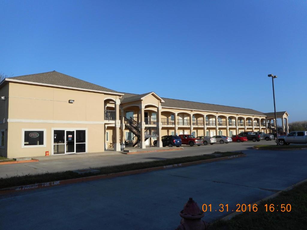 a large building on a street with a parking lot at Crossroads Inn & Suites in Victoria