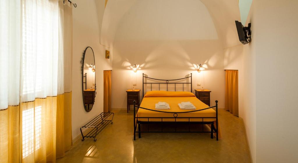 1 dormitorio con 1 cama con sábanas amarillas y ventana en B&B La Garolla, en Sannicola