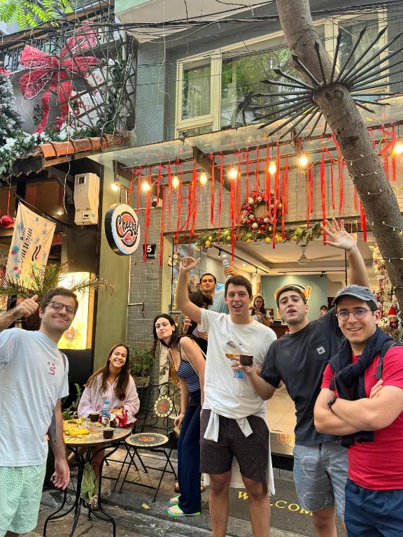 a group of people standing in front of a restaurant at Cheers Hostel Hanoi in Hanoi