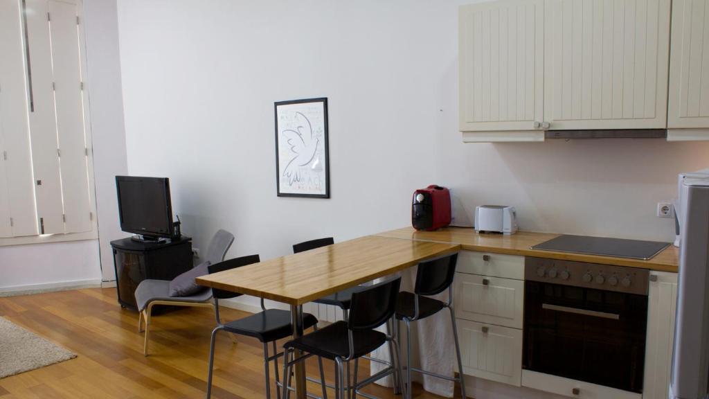 a kitchen with a wooden counter top and a table at Porto Beach House in Porto