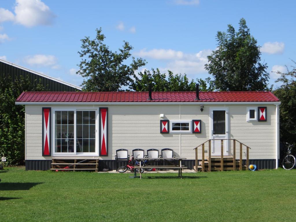 una casa pequeña con techo rojo en un patio en Boerderijcamping Plantlust, en Veere