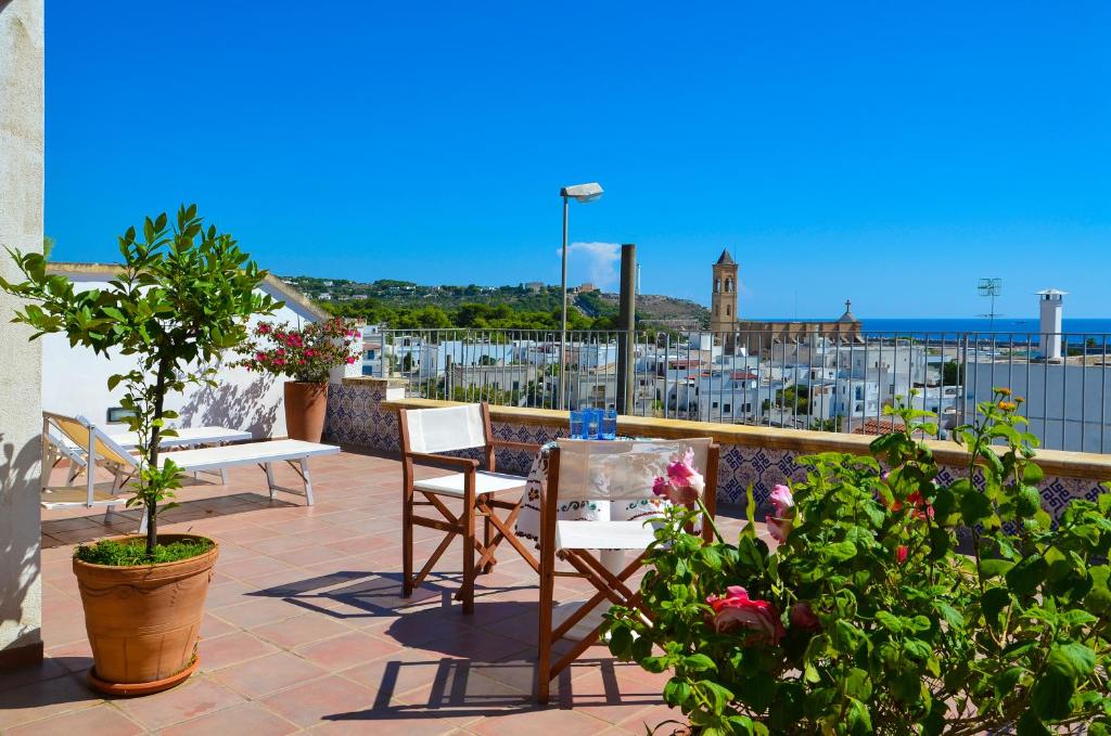eine Terrasse mit zwei Stühlen, einem Tisch und einigen Pflanzen in der Unterkunft Casa dell'Ospite in Santa Maria di Leuca