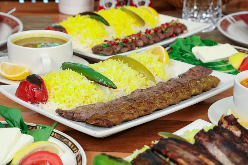 a table topped with plates of food with sausages and rice at Holiday Inn Kuwait Al Thuraya City by IHG in Kuwait