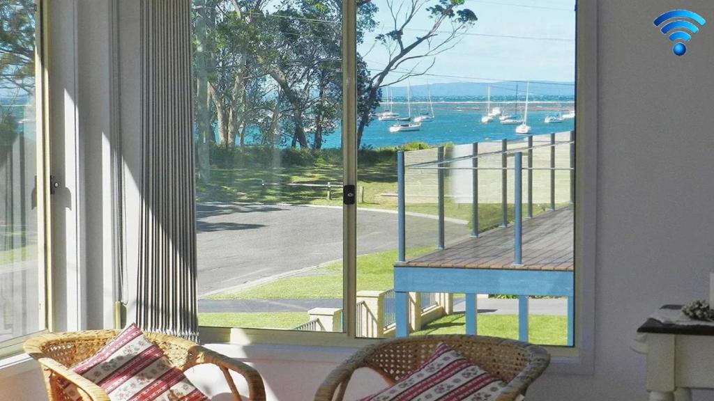 a room with a window with a view of a dock at Sealark in Callala Bay
