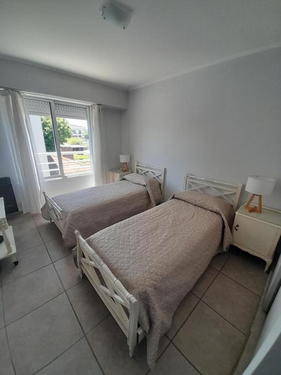 une chambre avec deux lits et une fenêtre dans l'établissement Departamento MICHE, à Tandil