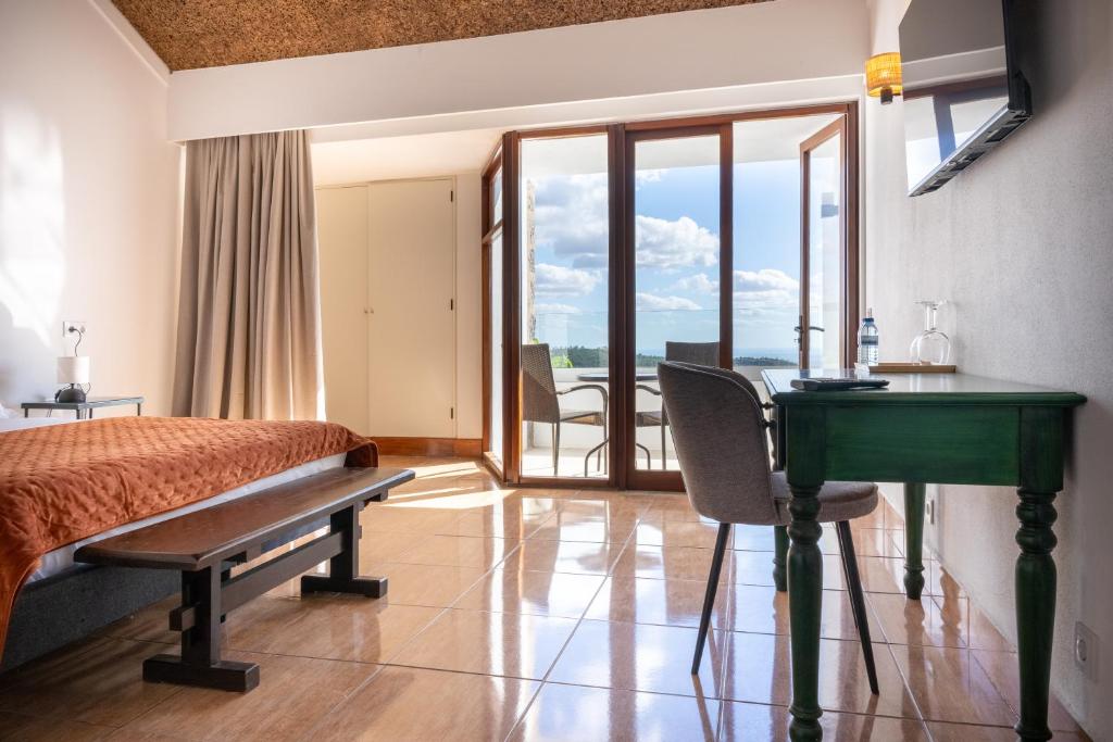 Un pat sau paturi într-o cameră la Aqua Vista Monchique Hôtel