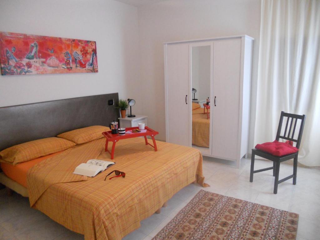ein Schlafzimmer mit einem Bett, einem Tisch und einem Stuhl in der Unterkunft Salvia e Timo Holiday Apartments in Borso del Grappa