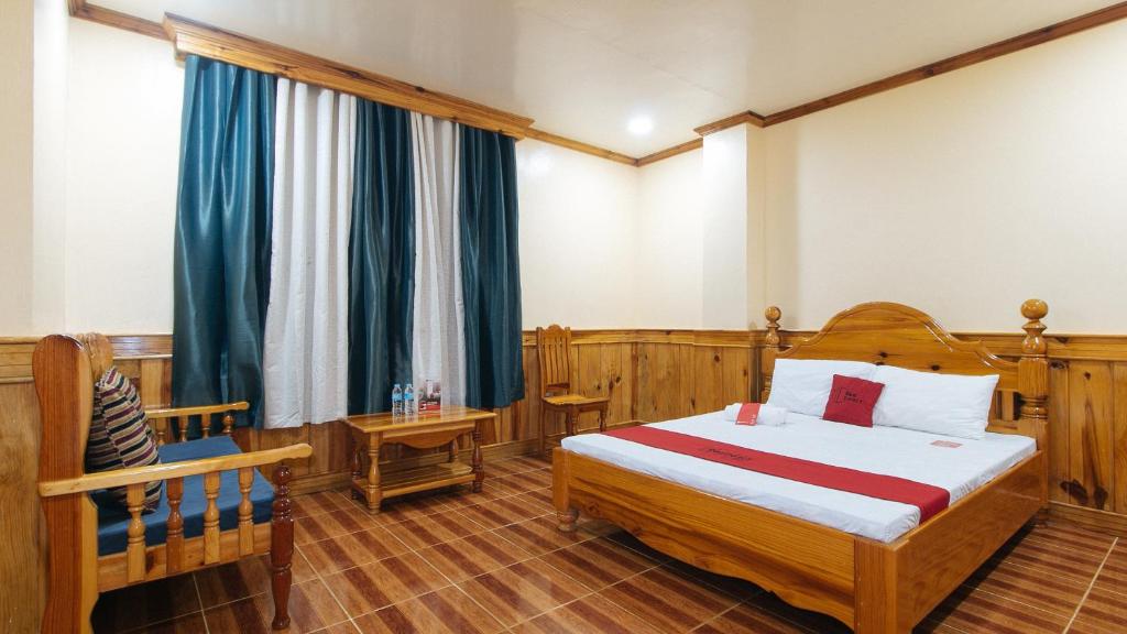 a bedroom with a bed and a chair in it at RedDoorz @ Sagada Sunrise View Homestay in Sagada