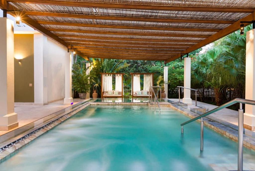 a swimming pool in a house with a wooden ceiling at Family Villa, Pool & Exclusive Resort Access in Playa Conchal