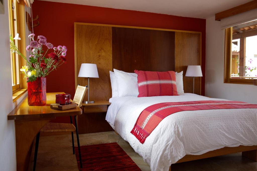 una camera da letto con un letto e un tavolo con un vaso di fiori di Casa Tsaya Hotel Boutique a Bernal