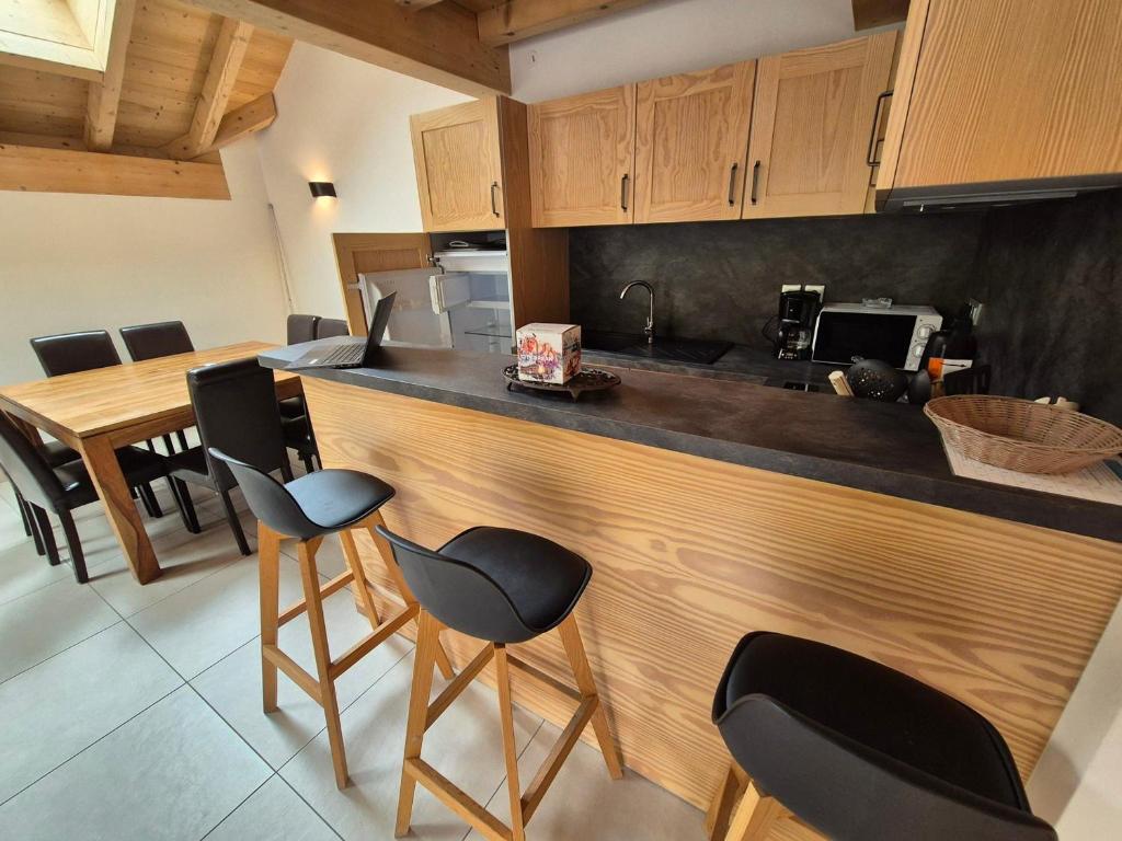 - une cuisine avec un bar avec des chaises et un comptoir dans l'établissement Duplex lumineux 8 pers, proche pistes, animaux ok - FR-1-811-29, à Les Deux Alpes