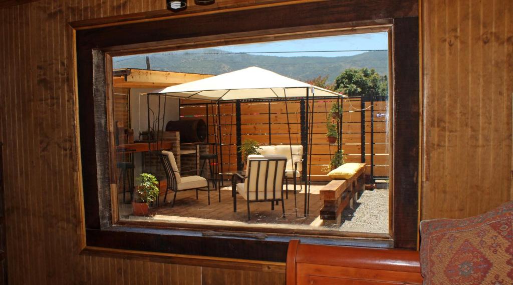 a mirror reflecting a patio with chairs and an umbrella at Arce Marron in Limache