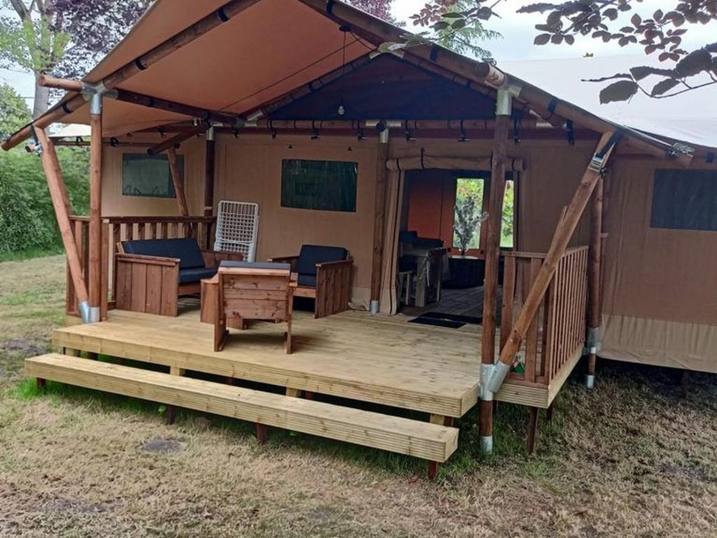 un kiosque avec une terrasse couverte et une terrasse dans l'établissement Cabane Trappeur Lodge avec Jacuzzi et Ferme Pédagogique - FR-1-410-458, à Cérans-Foulletourte
