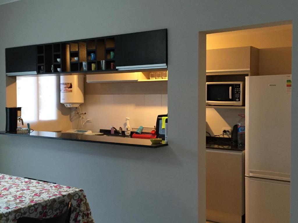 cocina con encimera y nevera en Apartamento 5 Carcano en Villa Carlos Paz