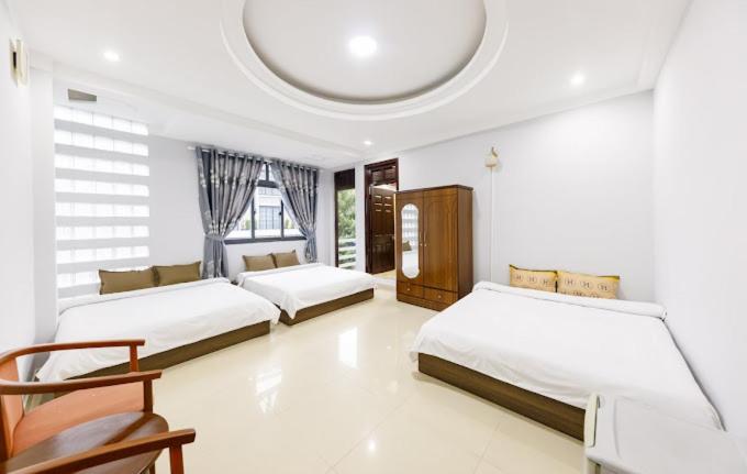 une chambre blanche avec deux lits et une chaise dans l'établissement Villa Thol DL - by BAY LUXURY, à Đà Lạt