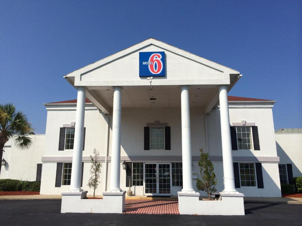 a large white building with a sign on it at Motel 6-Brunswick, GA in Brunswick
