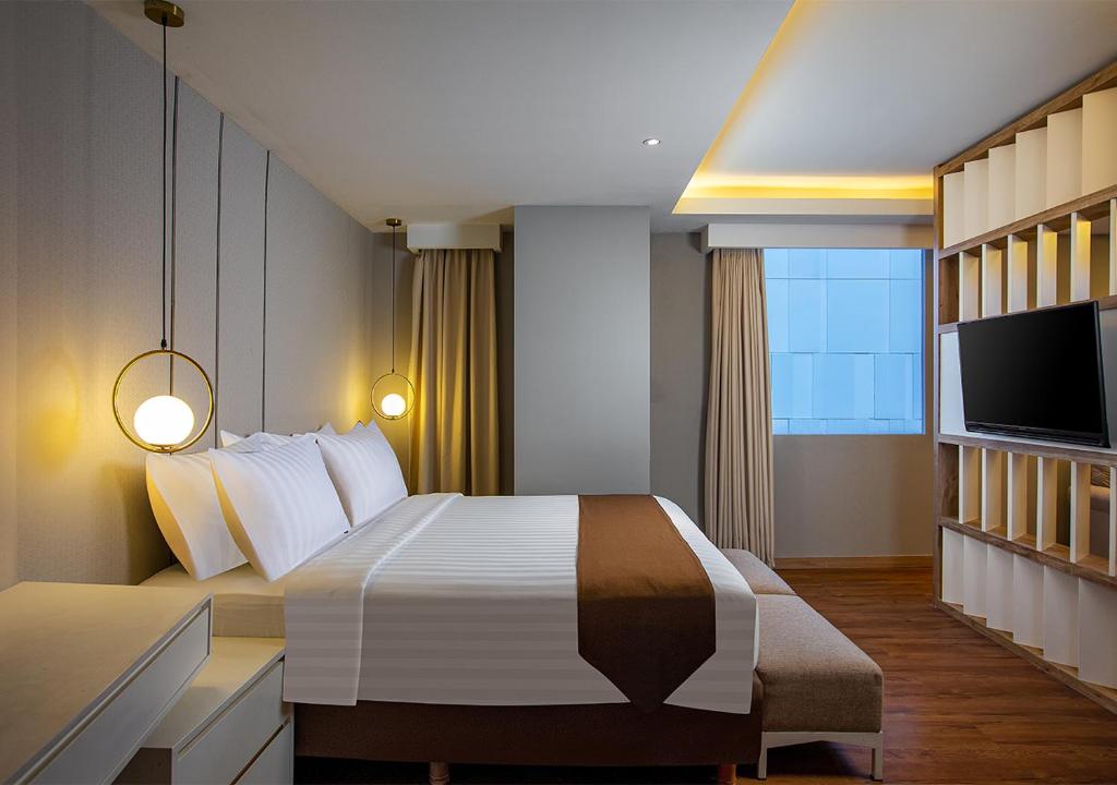 Postel nebo postele na pokoji v ubytování PRIME PARK Hotel & Convention Pekanbaru