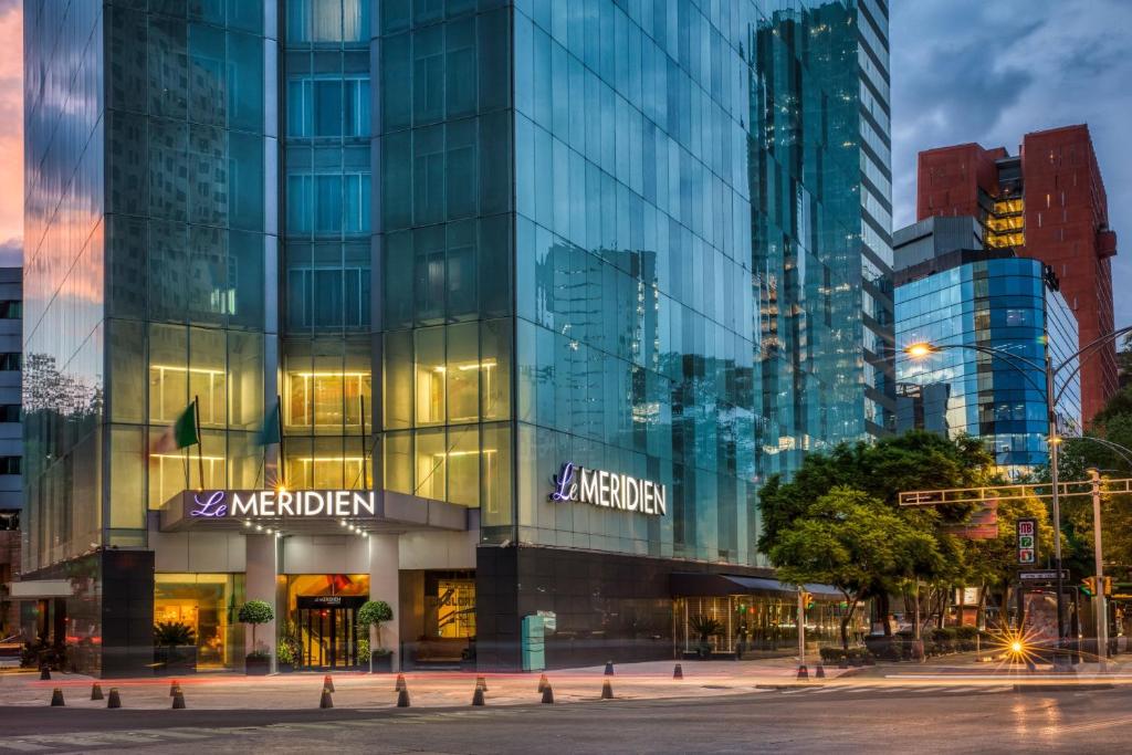 a large glass building in a city at night at Le Méridien Mexico City Reforma in Mexico City