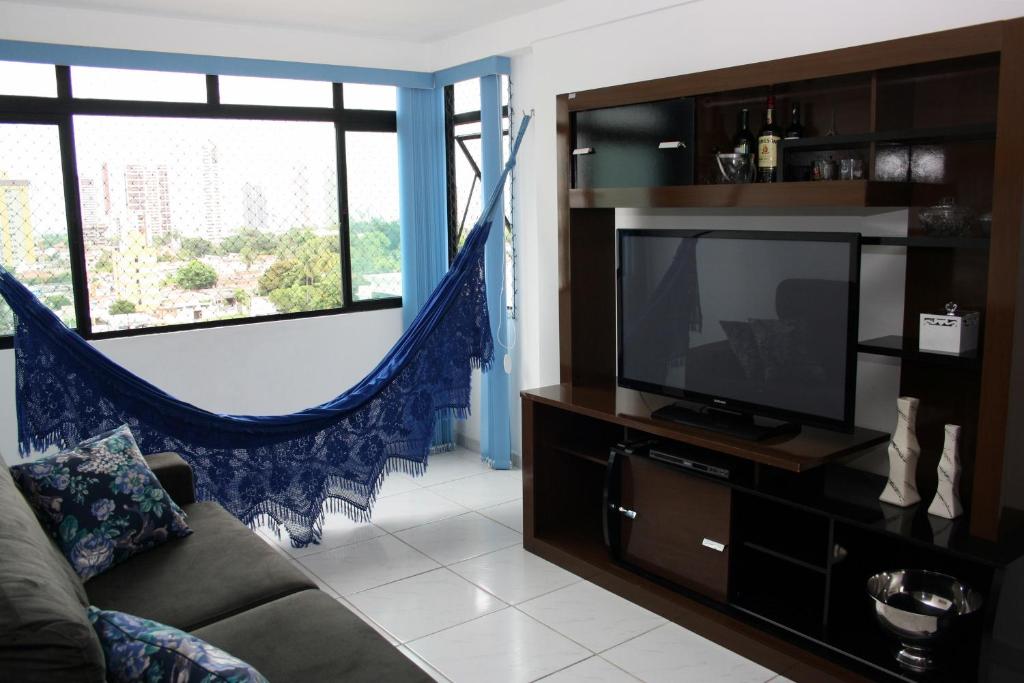 sala de estar con sofá y TV en Apartamento Green Park, en João Pessoa