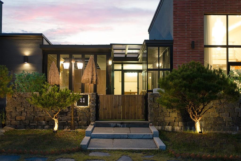 a house with a gate and a brick wall at Huerim Pool Villa Private Pension in Gyeongju