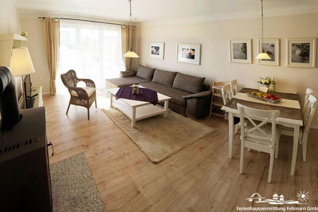 una sala de estar con un sofá y una mesa en 27 Ferienwohnung an der Reiterkoppel 49a EG, en Burg auf Fehmarn