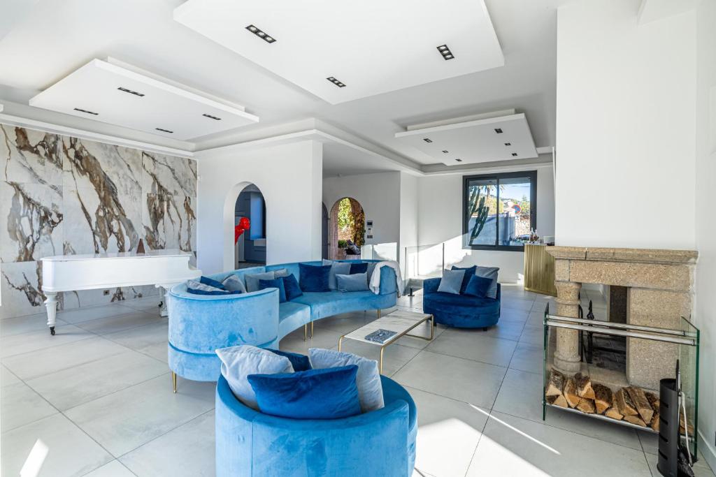 Elle comprend un salon doté d'un mobilier bleu et d'une cheminée. dans l'établissement New! Villa de luxe centre Cannes, à Cannes
