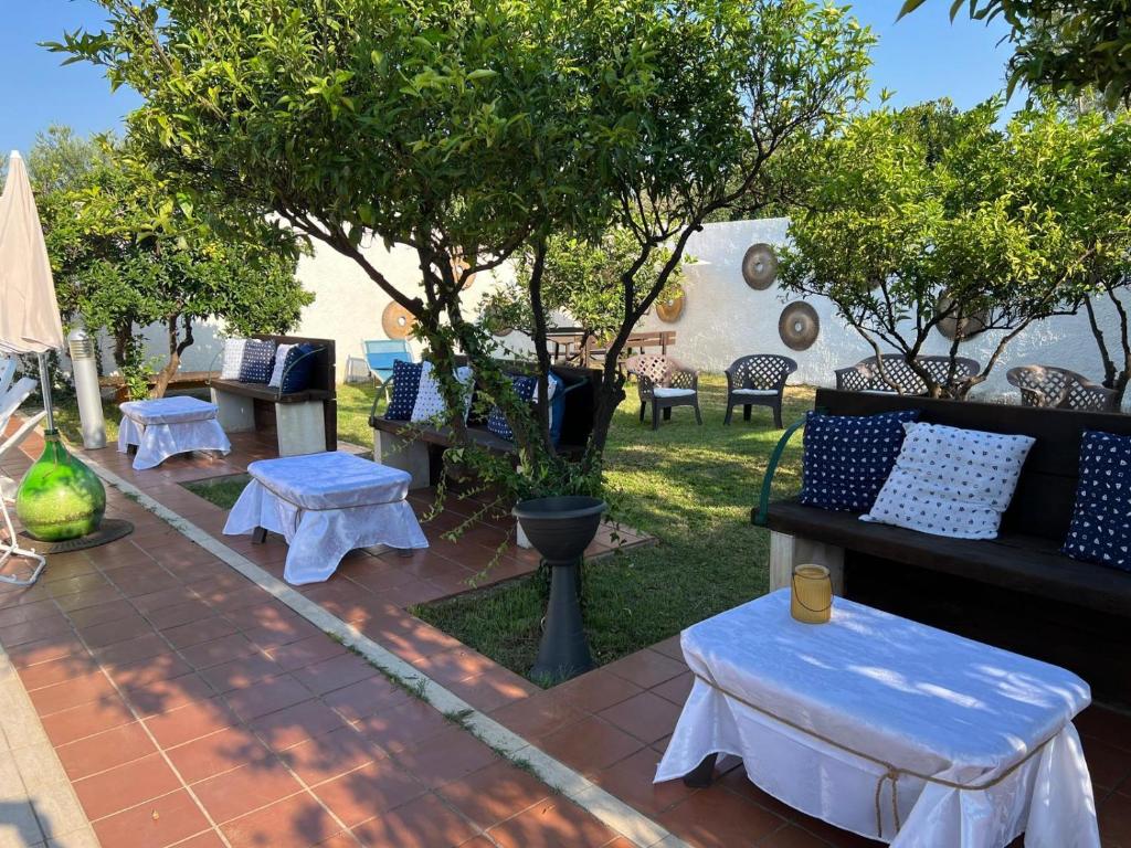 a patio with couches and tables in a yard at Casal Mastro appartamenti e camere con piscina in Bisceglie