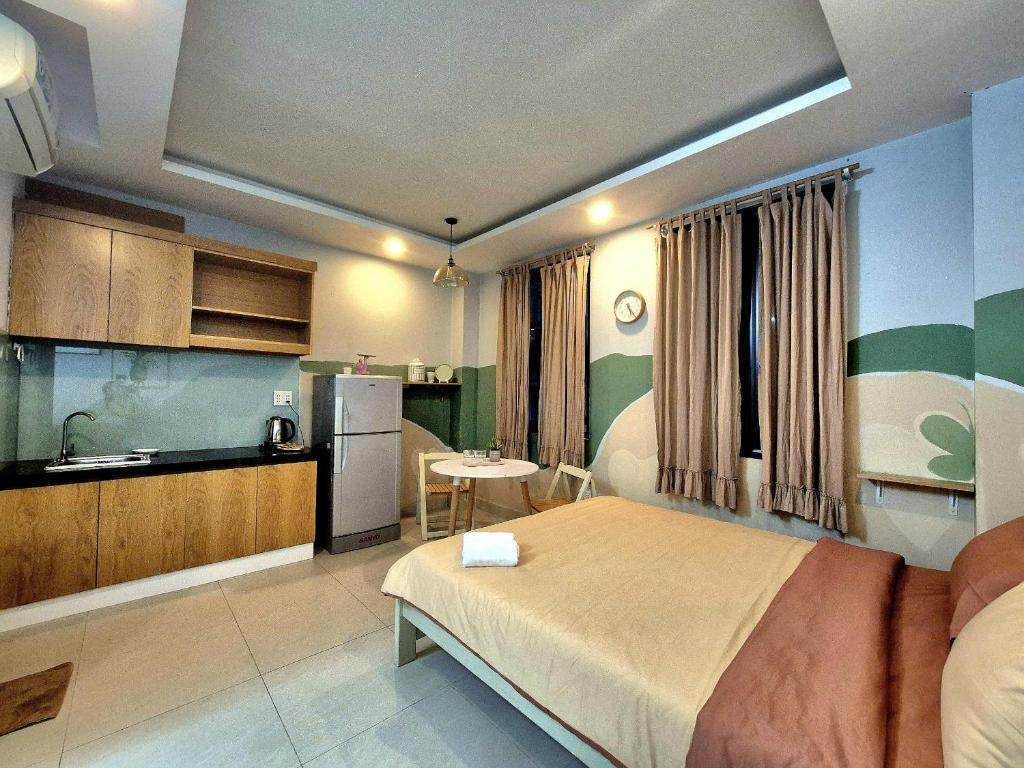 ein Schlafzimmer mit einem großen Bett und eine Küche in der Unterkunft FF Homestay Evy House in Ho-Chi-Minh-Stadt