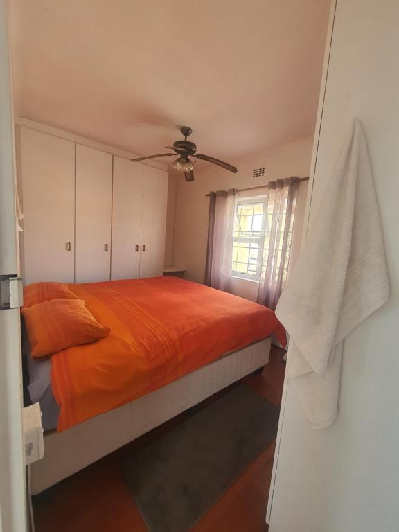 een slaapkamer met een bed en een plafondventilator bij Lifestyl Cottage in Cape Town