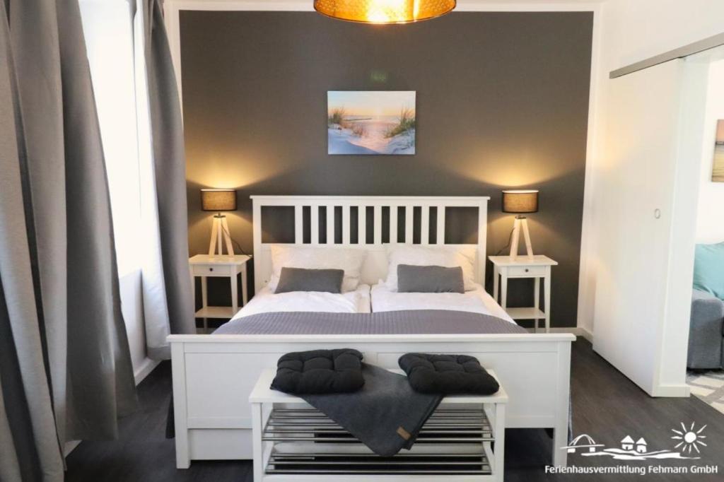 Un dormitorio con una cama blanca con dos mesitas de noche. en 38 Weiße Villa am Schwanenteich EG links, en Burg auf Fehmarn