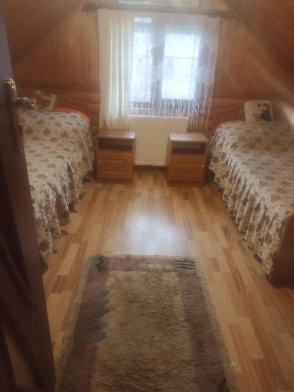 a bedroom with two beds and a window at Котедж "Хата Рибака" in Kosiv