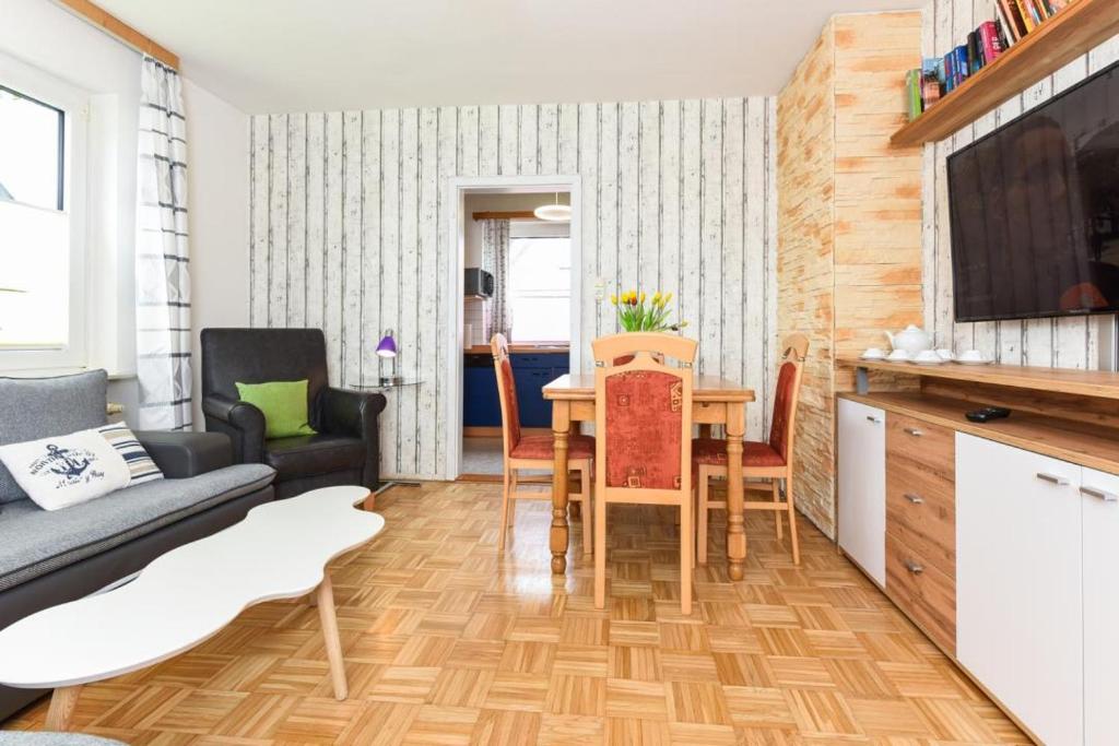 a living room with a table and a couch at Haus Kajedeich FeWo Seestern in Bensersiel