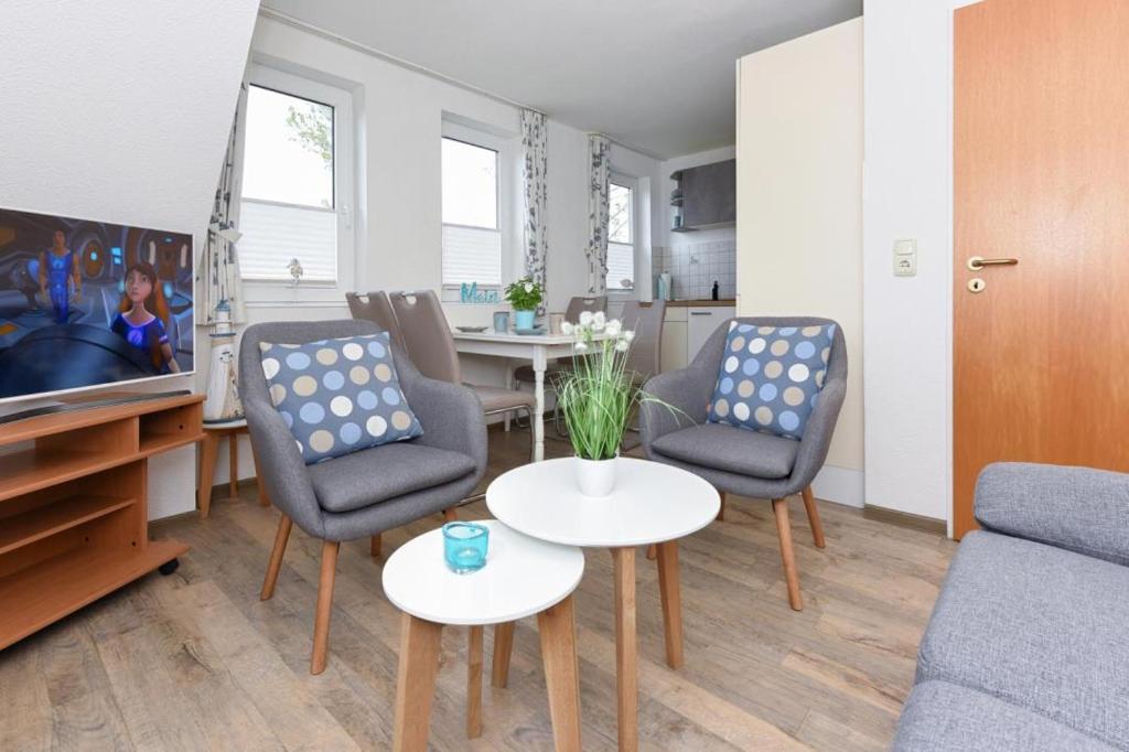a living room with a couch and chairs and a table at Haus Kajedeich FeWo Robbe in Bensersiel