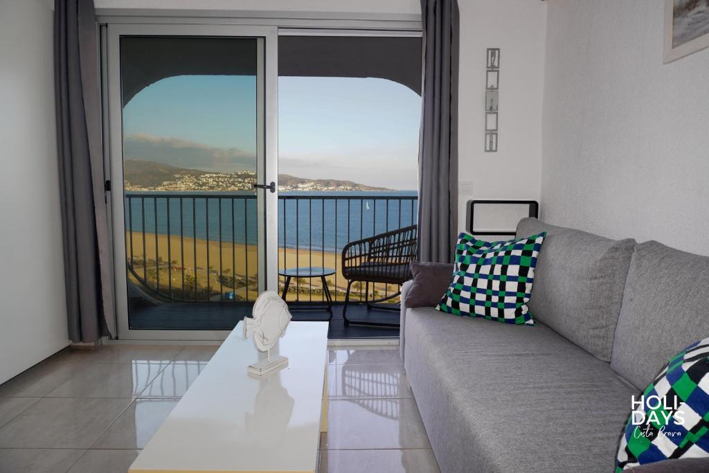 a living room with a couch and a view of the ocean at Holidays 15K Empuriabrava in Empuriabrava