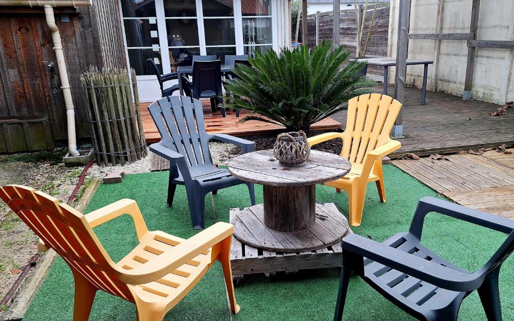 un groupe de chaises et une table sur une terrasse dans l'établissement Maison familiale avec grand jardin, à La Teste-de-Buch