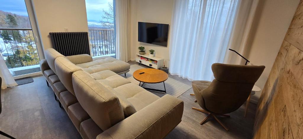 a living room with a couch and chairs and a television at Apartman so saunou, PRIMO Stary Smokovec in Smokovce
