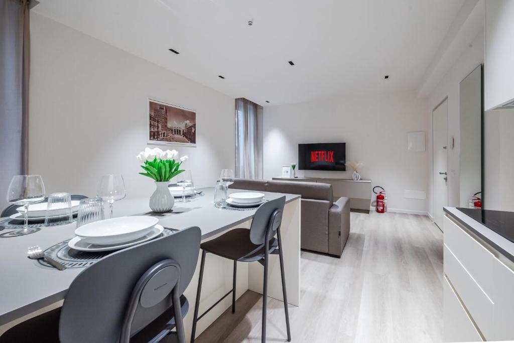 a white kitchen and dining room with a table and chairs at Vittoria Apt Luxury e Design in Duomo in Brescia