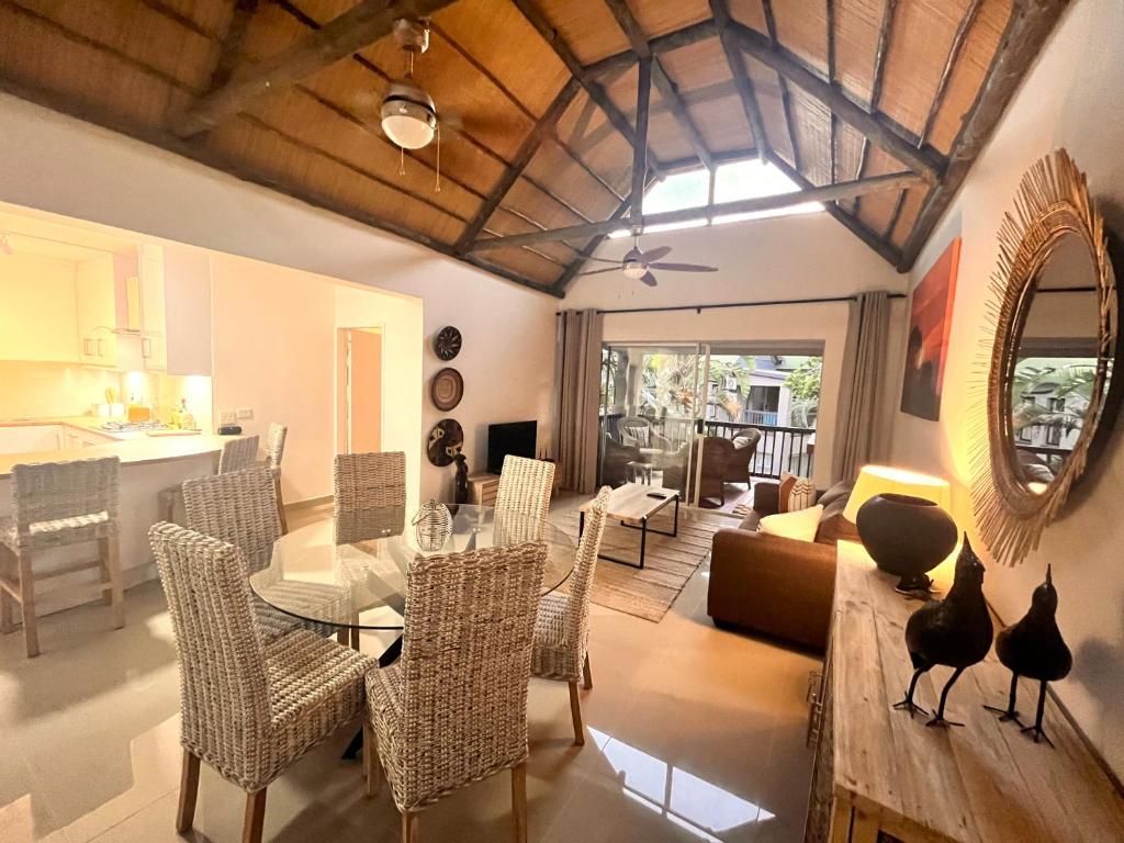 a dining room and living room with a table and chairs at Zulu Sunset Luxury Apartment in St Lucia