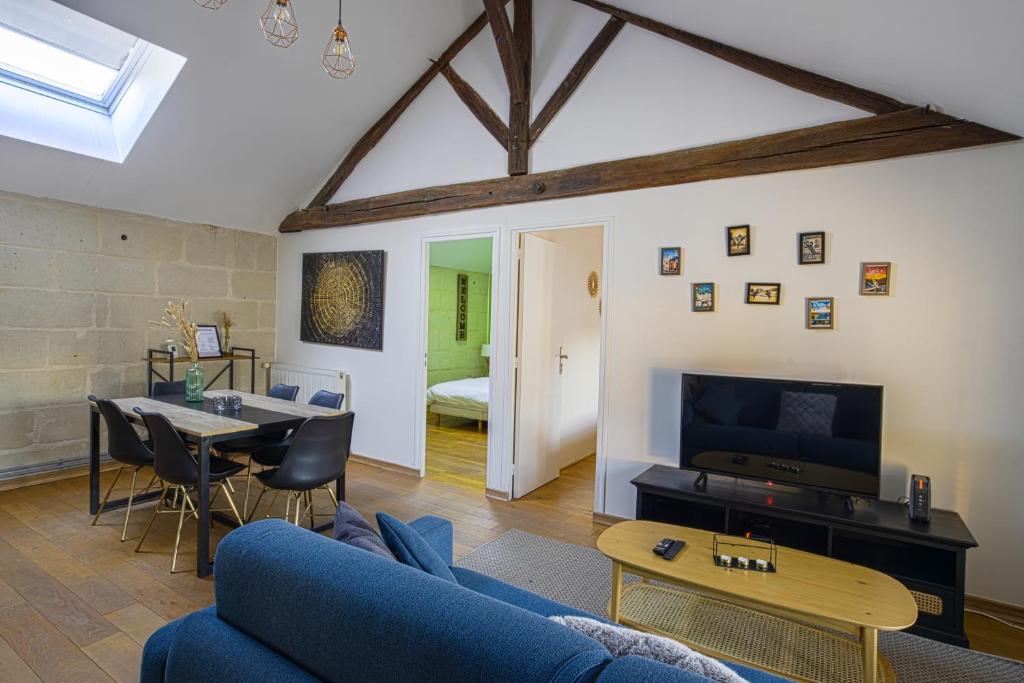 un salon avec un canapé bleu et une table dans l'établissement Grand logement 2 ch hyper-centre calme Wifi, à Saumur