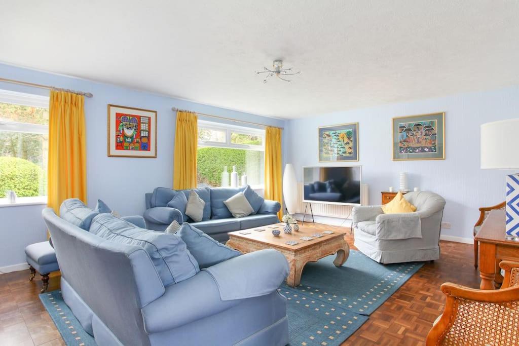 ein Wohnzimmer mit blauen Sofas und einem Tisch in der Unterkunft Wildwoods - just moments from the beach! in Worth