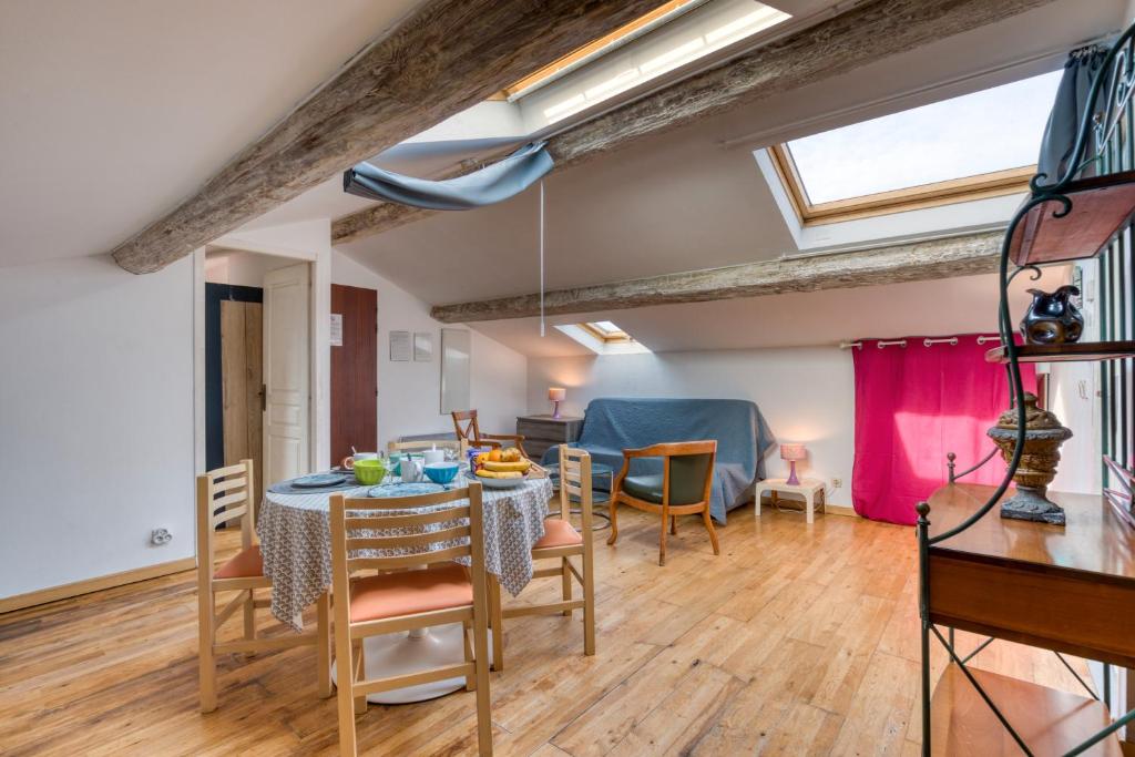 une salle à manger et un salon avec une table et des chaises dans l'établissement Appartement Le Colombier, à Béziers