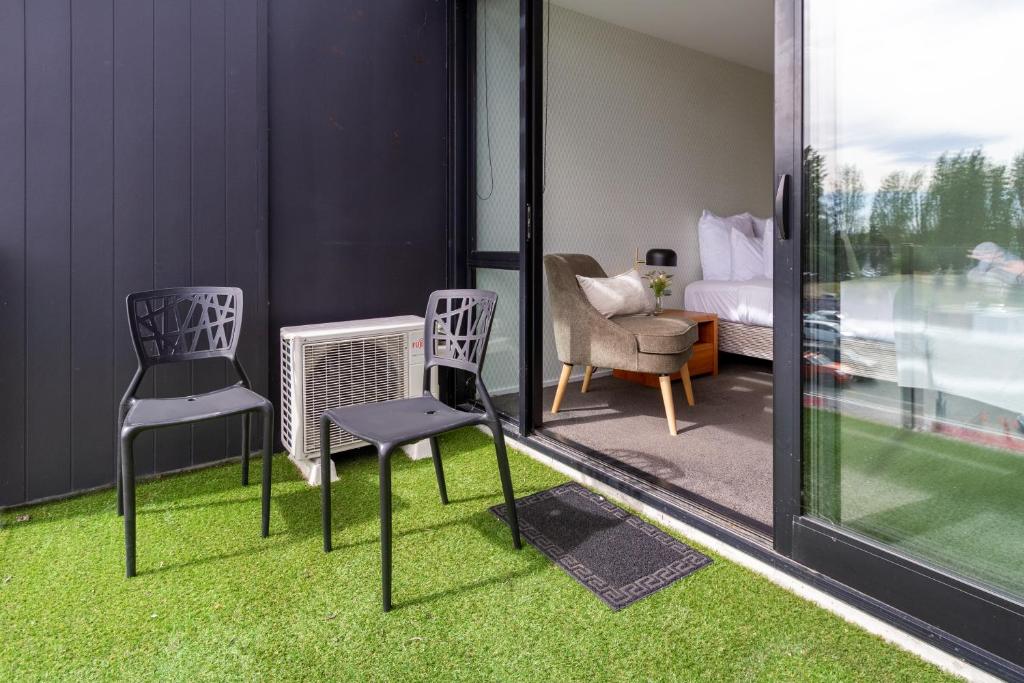 two chairs and a radiator in a room with grass at Studio with City Views in Central Christchurch in Christchurch
