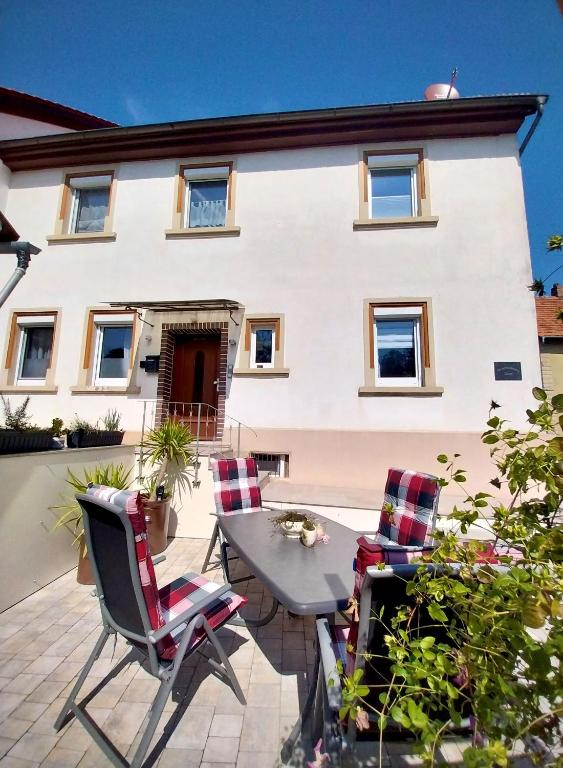 a patio with chairs and a table in front of a house at Ferienwohnung Düsel in Maroldsweisach