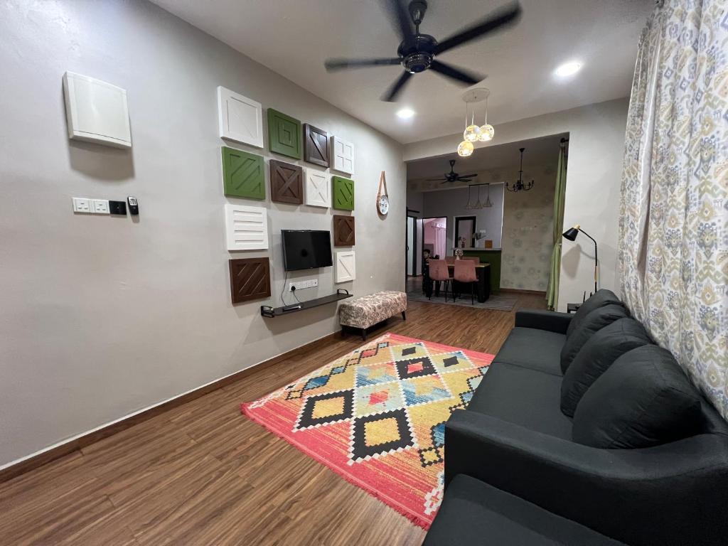 un soggiorno con un divano nero e una TV di La Calma Private Pool a Jitra