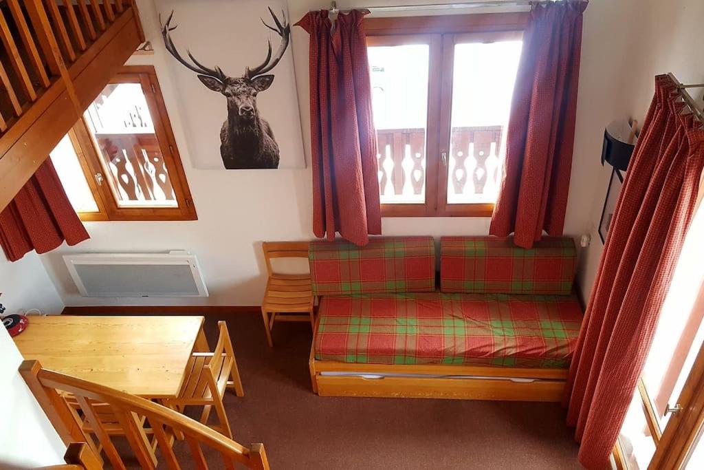 - un salon avec un canapé, une table et des fenêtres dans l'établissement RPP C208 - Apt 3 pièces duplex 6 8 pers, à Tignes