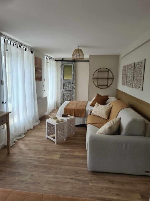 un salon avec un canapé et un lit dans l'établissement l'ANDRESE, à Hiéville