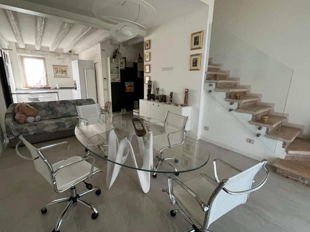 a living room with a glass table and chairs at Stellina in Mozzecane