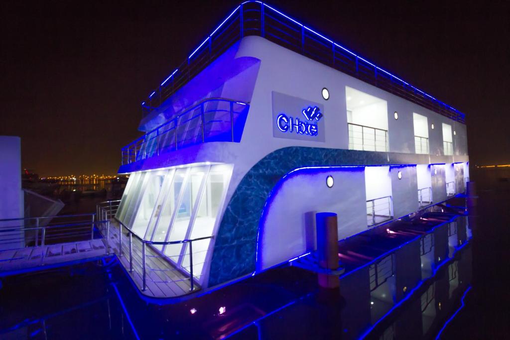 un bâtiment avec des lumières bleues sur son côté dans l'établissement C Hotel, à Manama