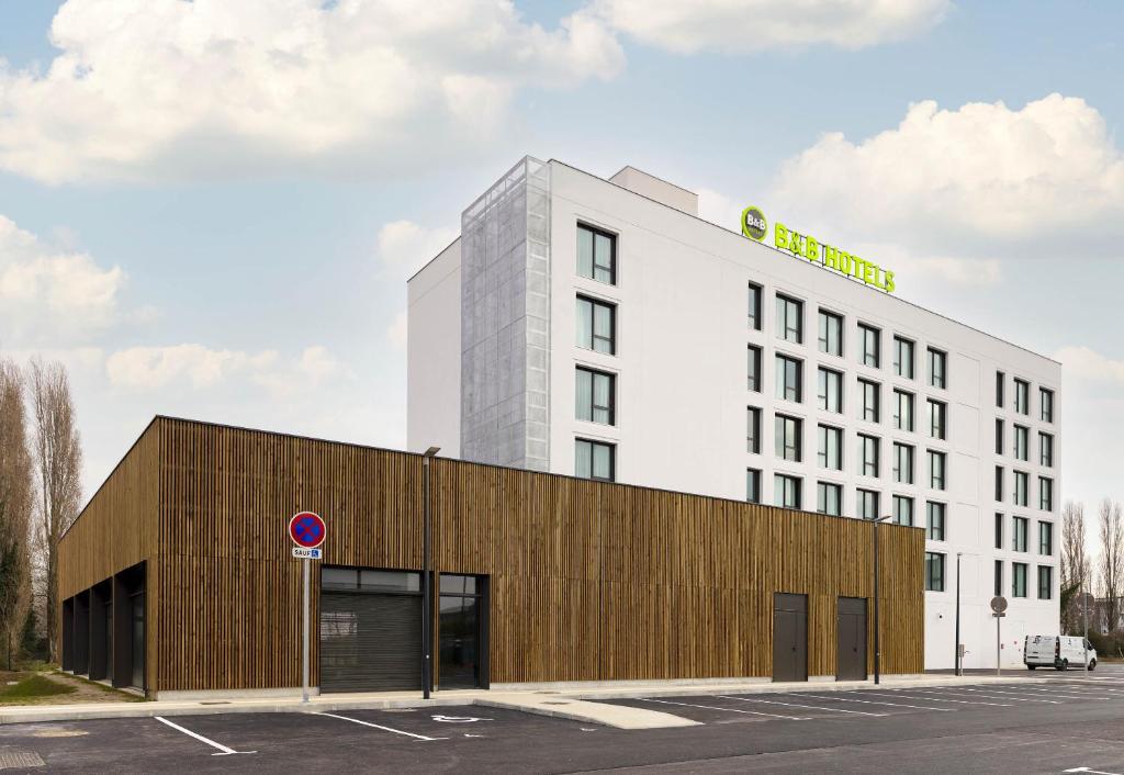 a white building with a sign on top of it at B&B HOTEL Cergy Saint-Christophe Gare in Cergy