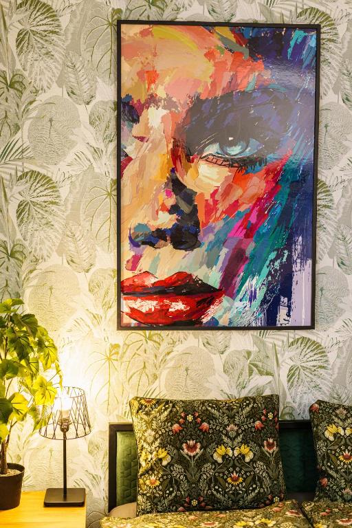 Hotel Greenland Family Premium Central Apartment, a painting of a woman on a wall with a couch at Greenland Family Premium Central Apartment in Budapest
